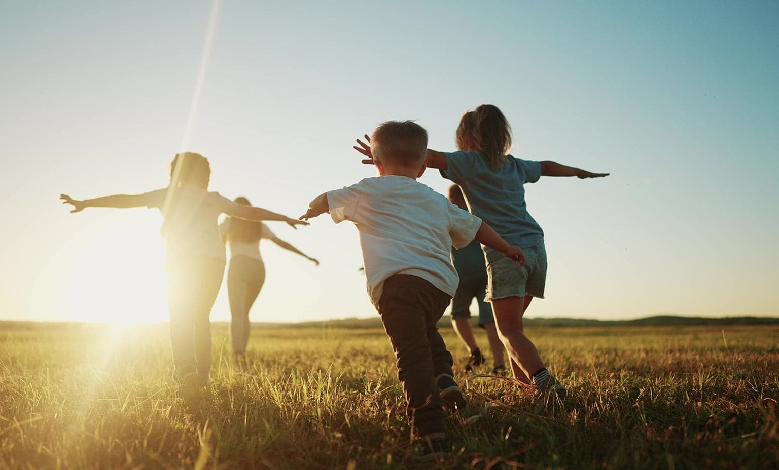 kids running through a sunny field